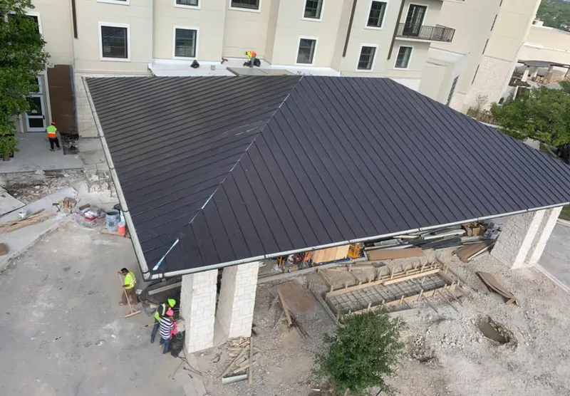 Metal roofing installation team working on a commercial building in Independence